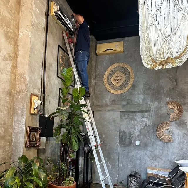 Técnico instalando ar-condicionado em escada